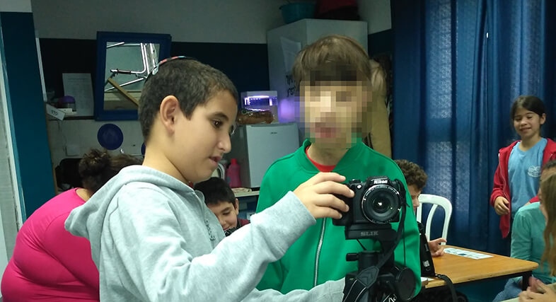 תלמיד מסביר לתלמיד אחר על המצלמה